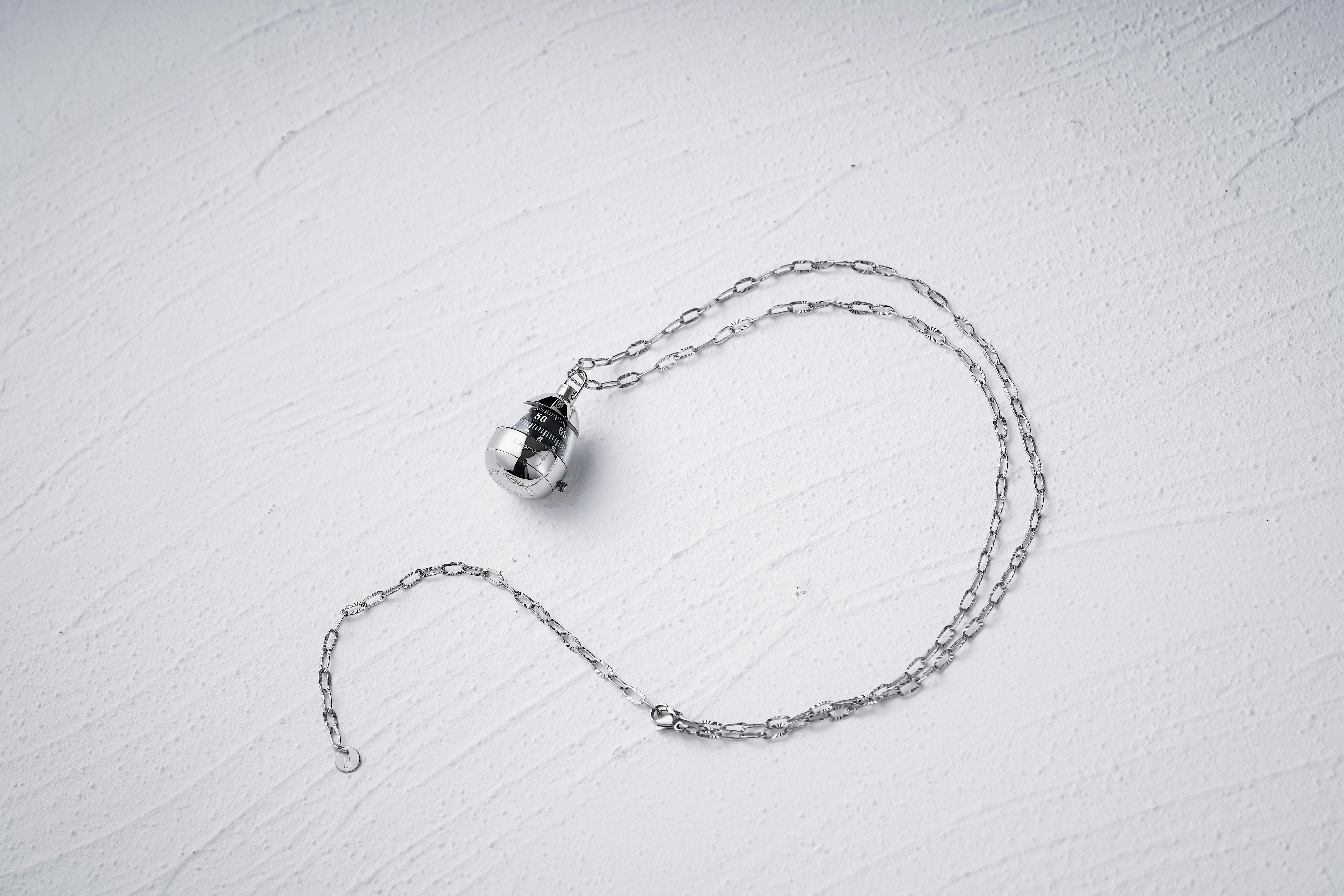 Silver hamsa hand pendant necklace styled in flat lay on neutral surface