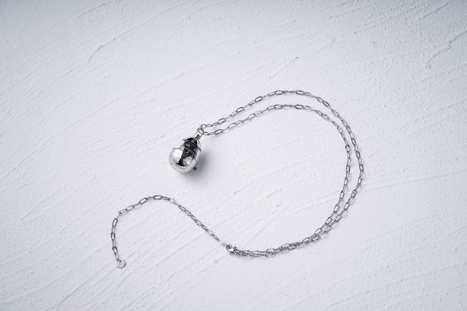 Silver hamsa hand pendant necklace styled in flat lay on neutral surface