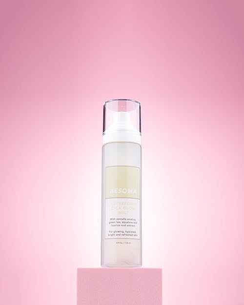 A Bottle with a Skincare Product Standing on Pink Background 