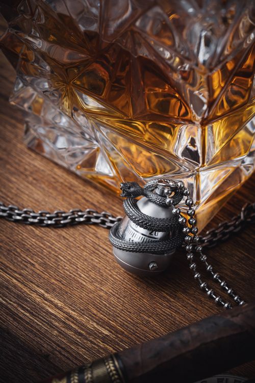 Free Close-up of a vintage snake egg watch with a crystal decanter on a wooden table. Stock Photo