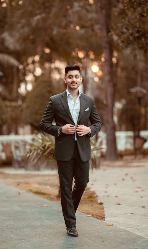 Photo of a Man Wearing a Suit Posing in a Park