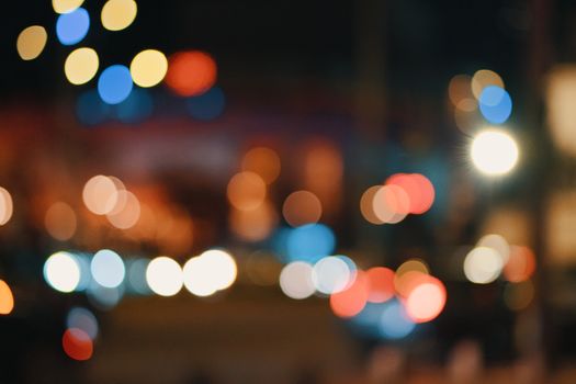 Defocused colorful city lights creating a vibrant bokeh effect during night.
