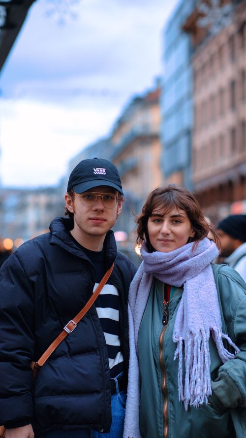 Free A young couple in winter jackets poses on a city street, showcasing urban lifestyle. Stock Photo