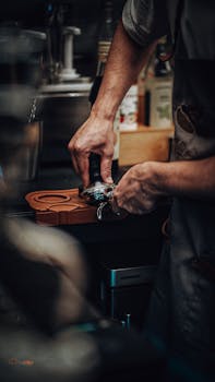 Close-up of a barista's hands preparing coffee at a machine in a café.