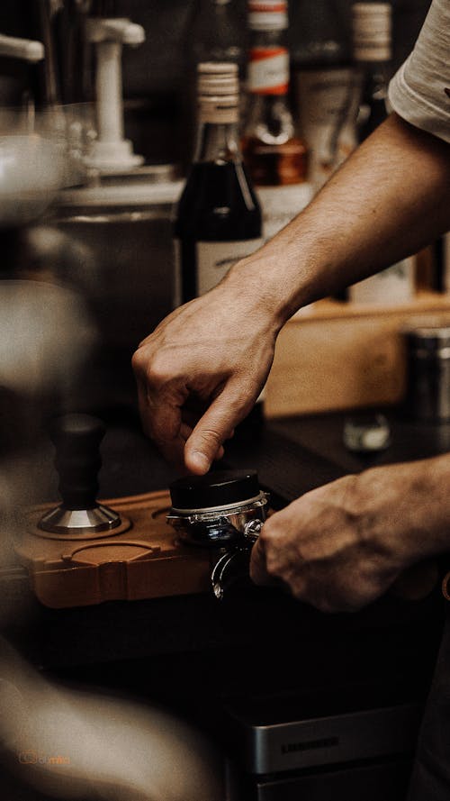 Close-up of a Barista Using a Coffee Stamp 