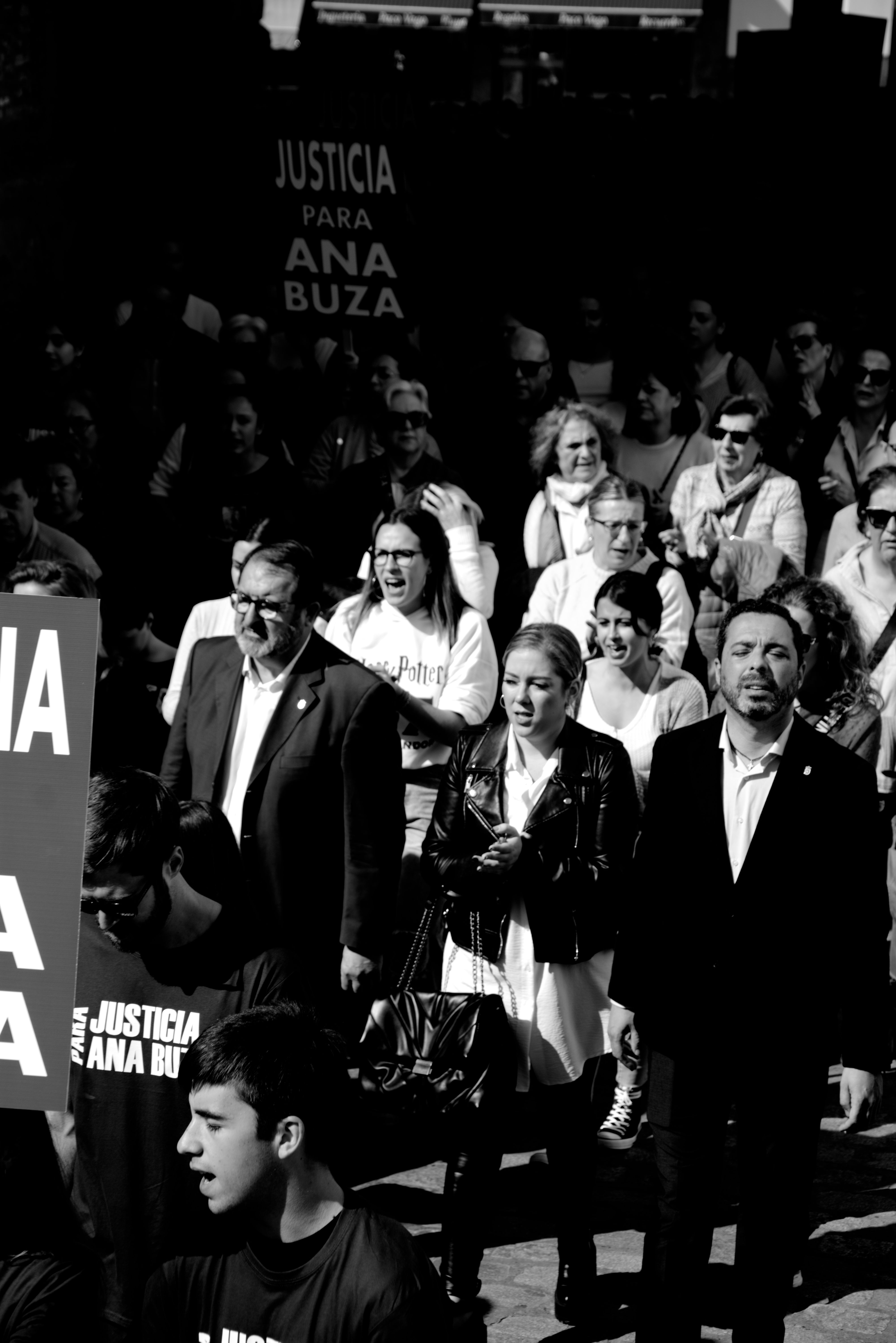 Crowd demonstrating for justice in Carmona, Spain with banners and signs.