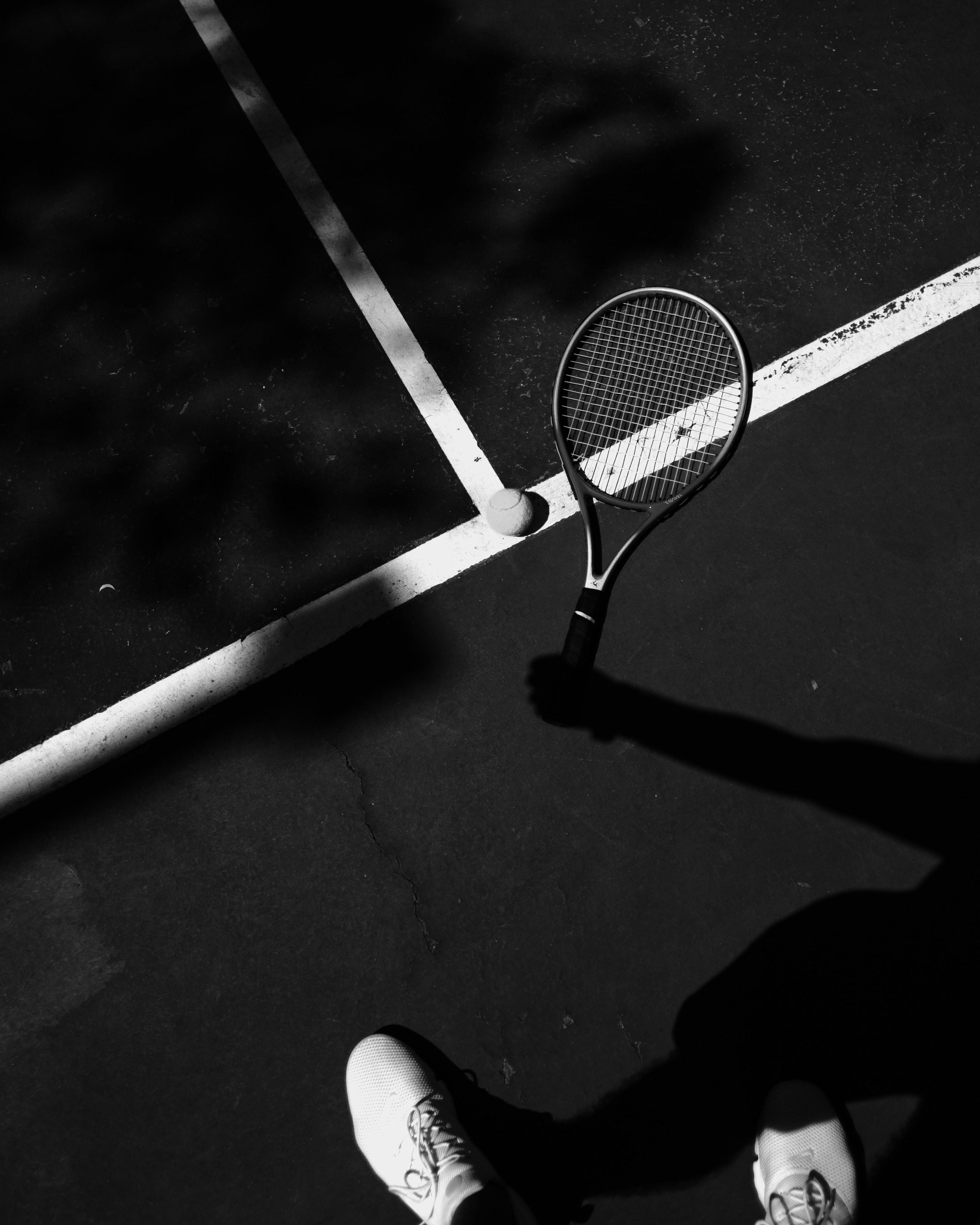 A Tennis Racket and a Tennis Ball on a Court next to a Person · Free