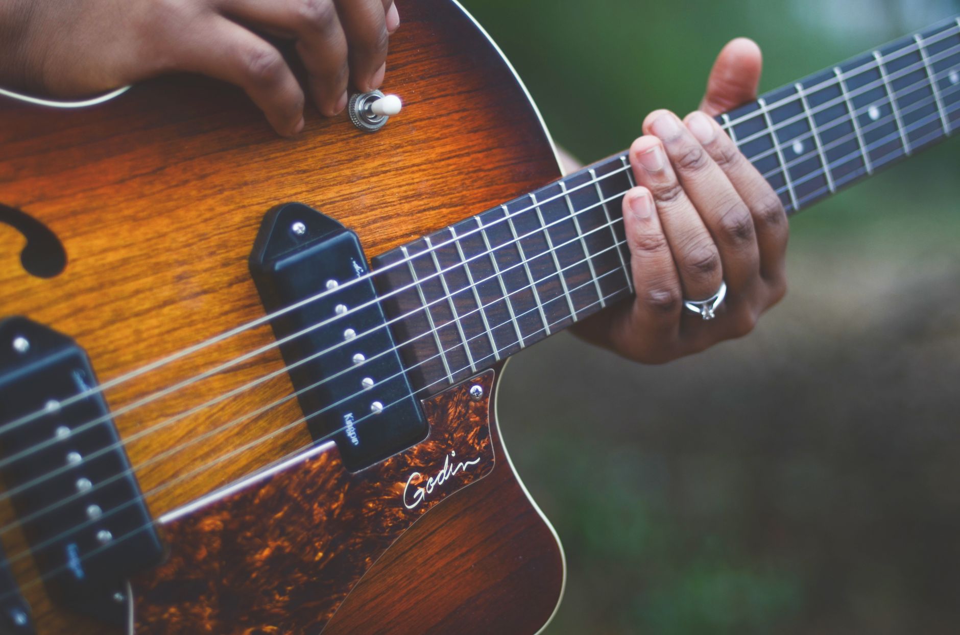 Detailed shot of hands playing a wooden electric guitar, showcasing musical talent.. detailed, shot, hands