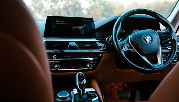 Close-up of a modern BMW vehicle's interior showcasing the dashboard, steering wheel, and digital screen.