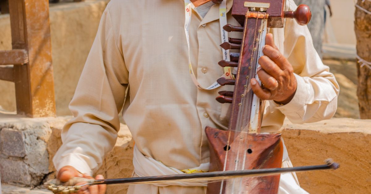 Man in Traditional Clothes and Headwear Playing Musical Instrument ...