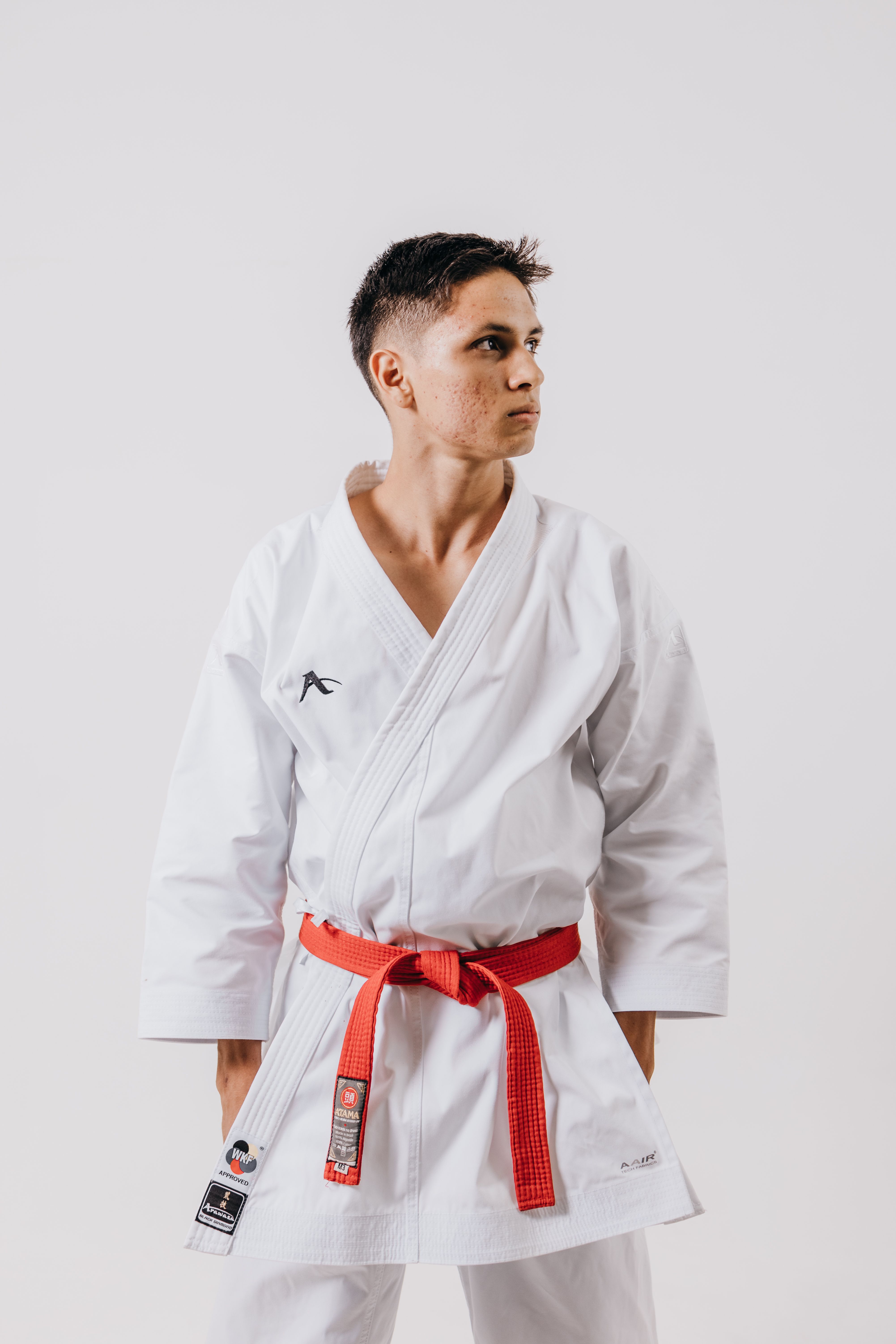 Karate athlete posing in traditional white gi with a red belt during a studio session.