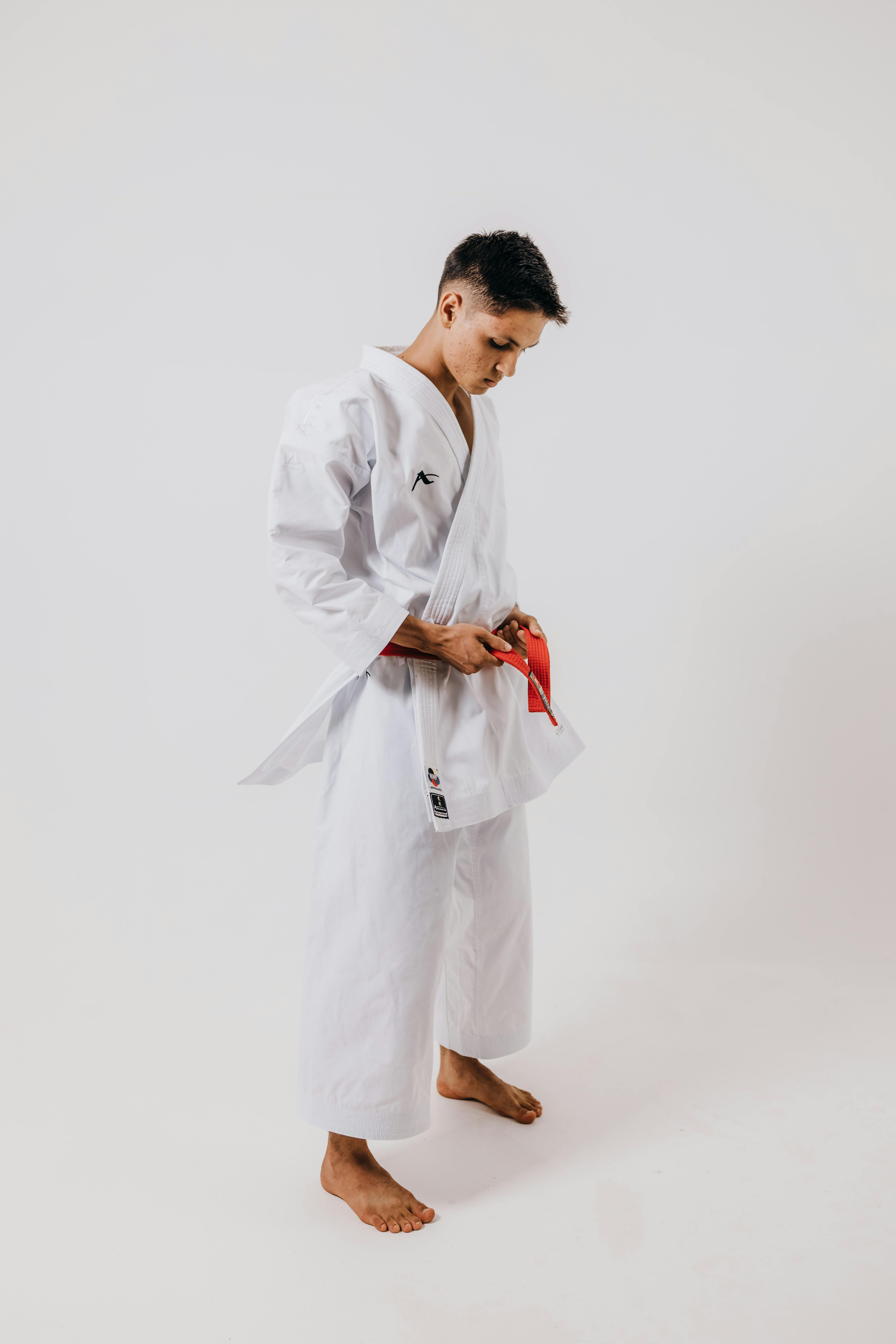 karate student tying the red belt on his arawaza kimono