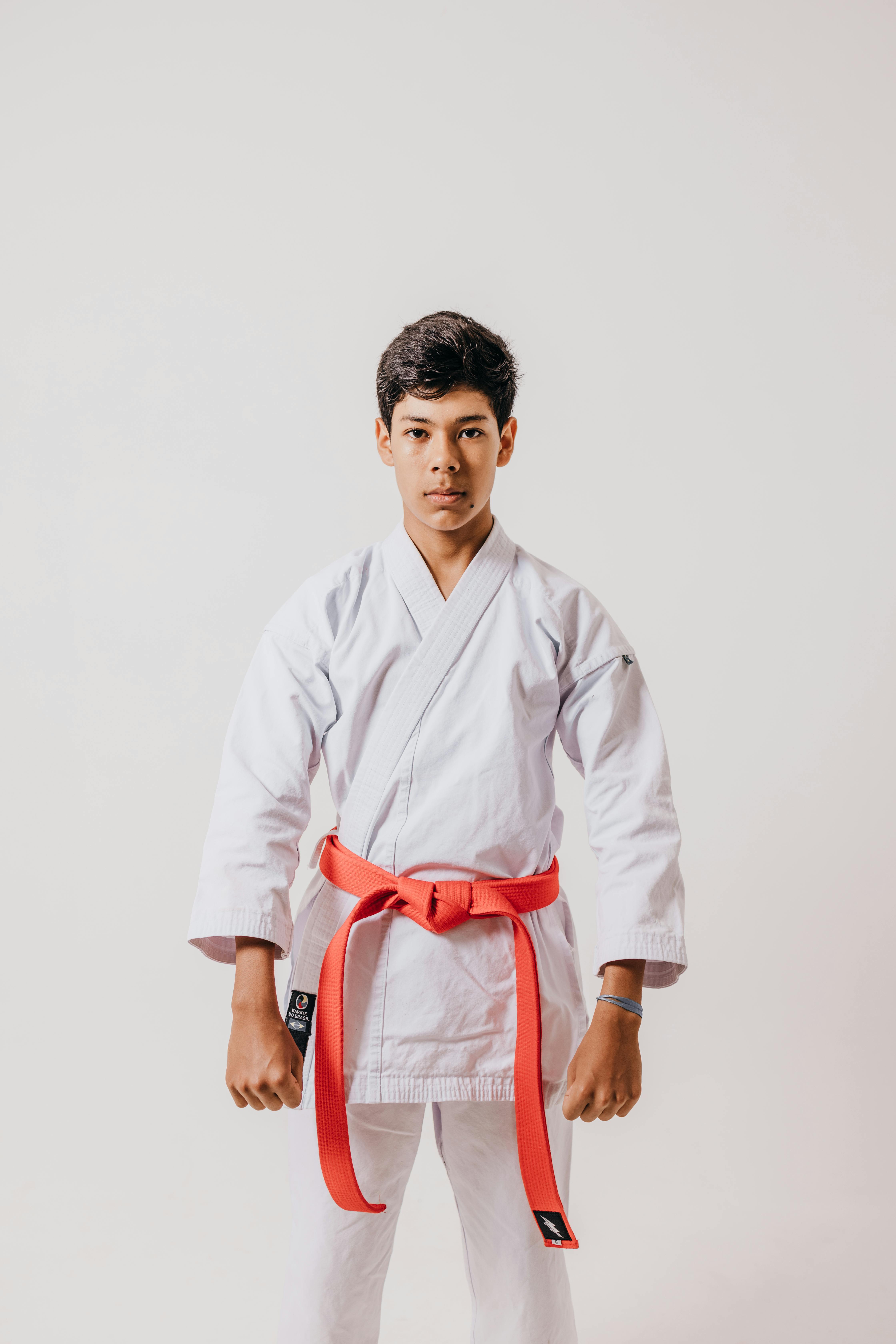 boy in a white kimono and a red belt posing in the studio