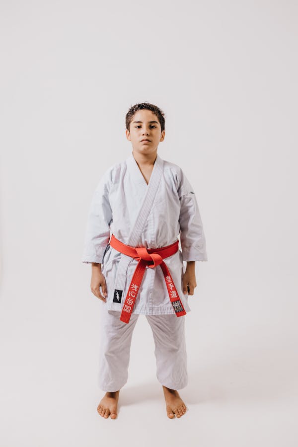 Young martial arts student in traditional karate uniform demonstrating focus and traditional discipline