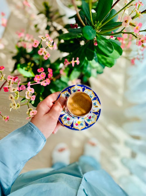 Hand Holding Plate with Coffee Cup