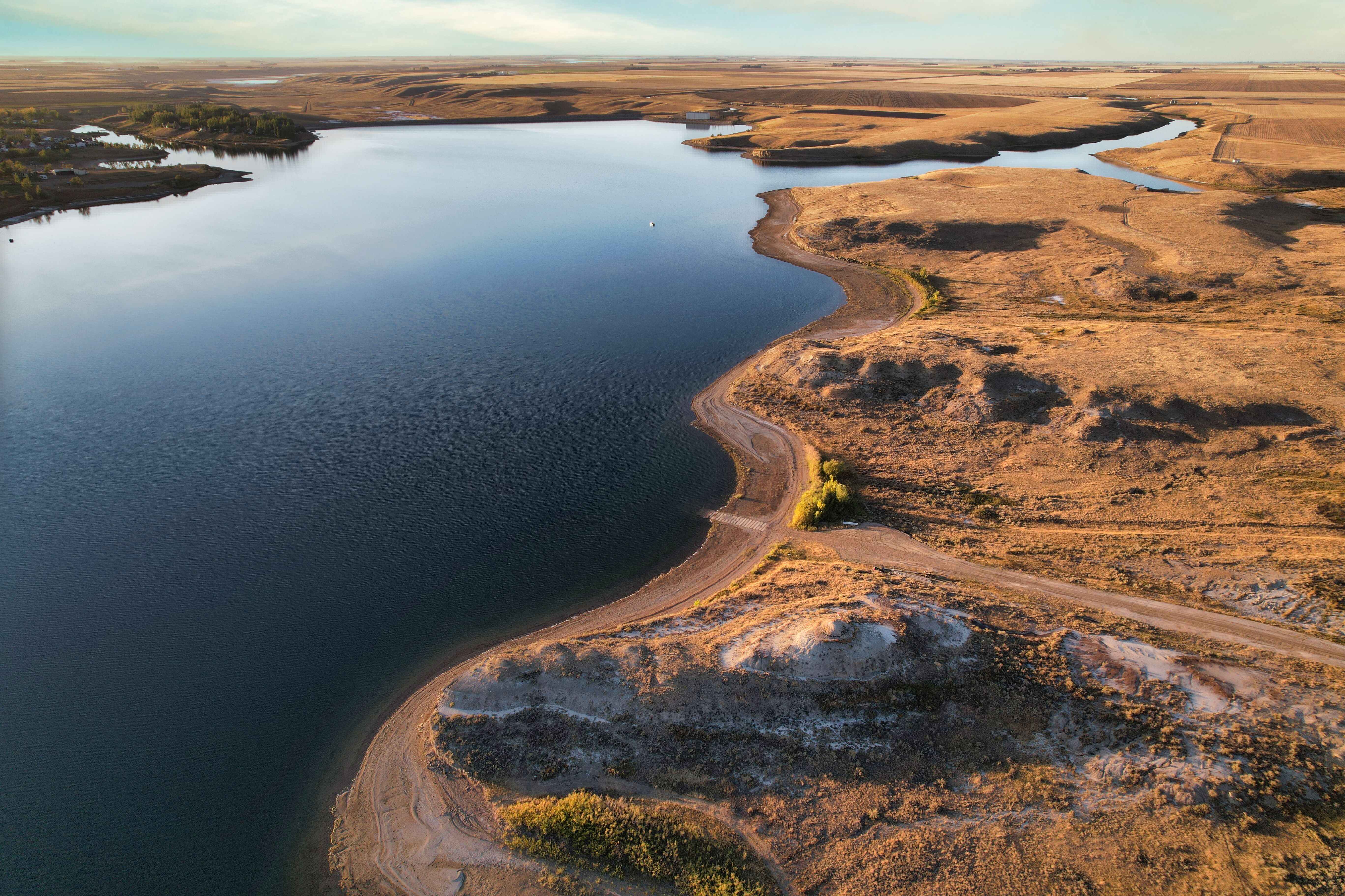 Aerial view capturing the serene beauty of lake and desert terrain during the day.