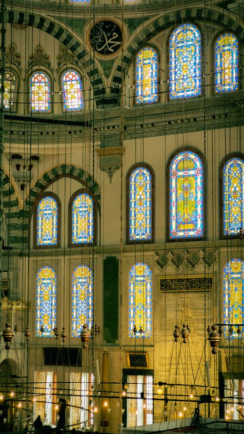 Free Beautiful interior of a mosque showcasing intricate stained glass windows and Islamic art. Stock Photo