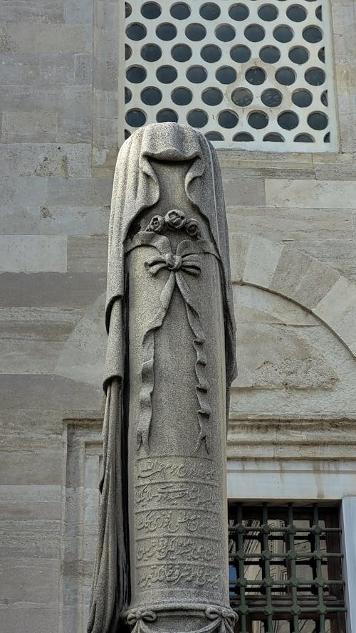 A Vertical Statue in front of a Building 