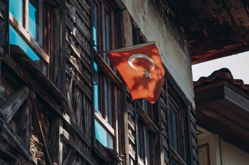 Free Turkish flag displayed on a rustic wooden building, capturing heritage beauty. Stock Photo