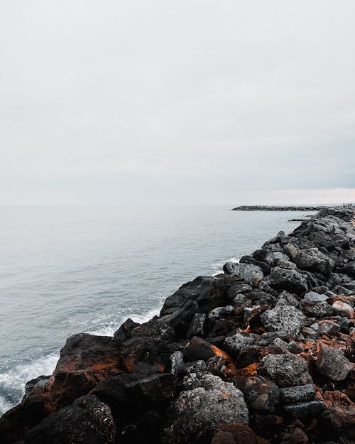 Rocks on Sea Shore under Clouds 