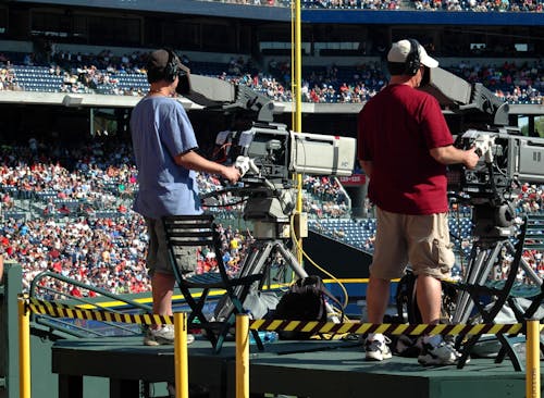 Free 2 Camera Man Standing in a Green Metal Stage during Daytime Stock Photo