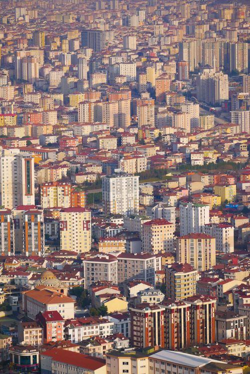 Free An aerial view of a densely populated city with numerous high-rise buildings under a sunlit sky. Stock Photo
