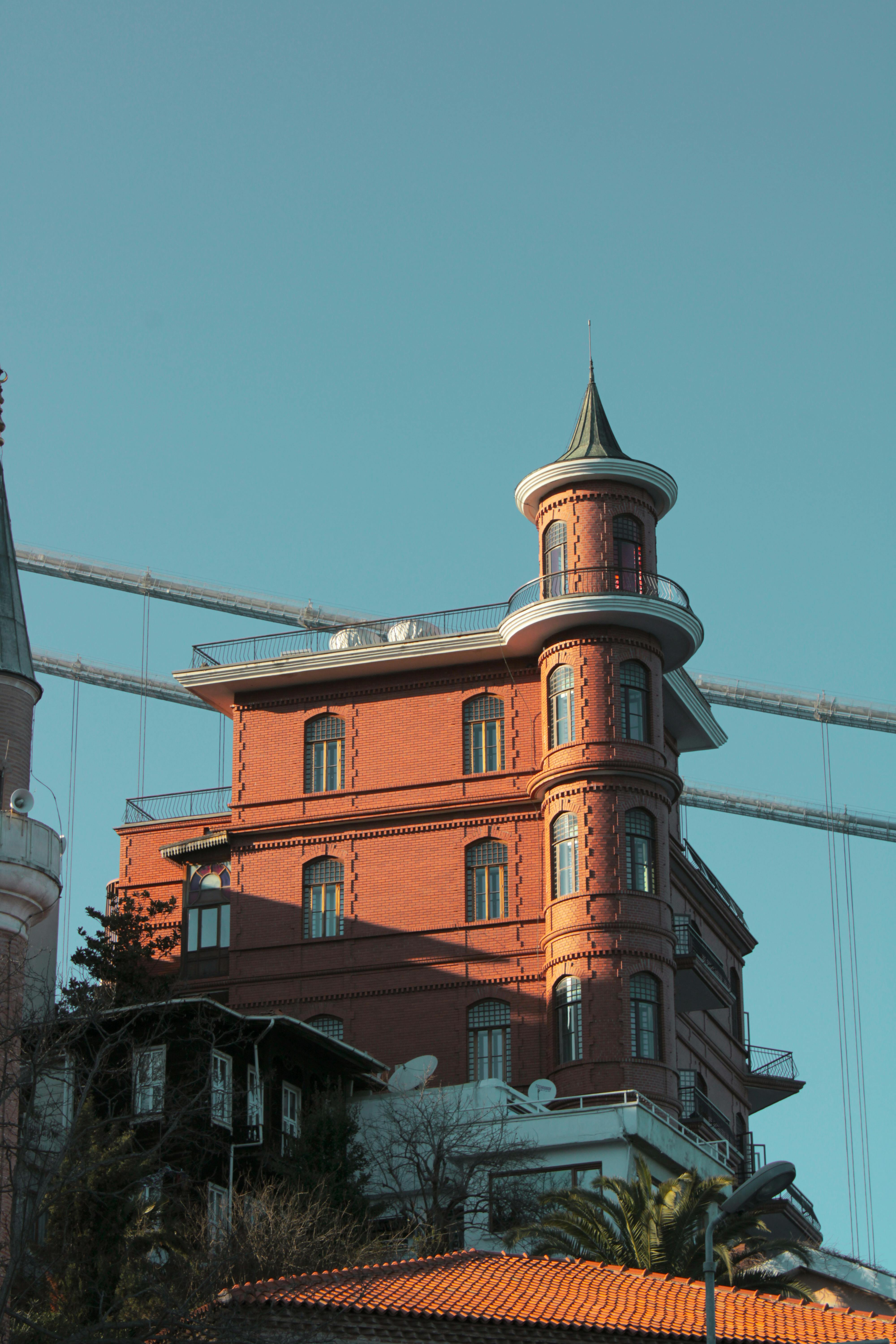Elegant sunlit mansion with tower in Istanbul, showcasing unique architectural design under a clear sky.