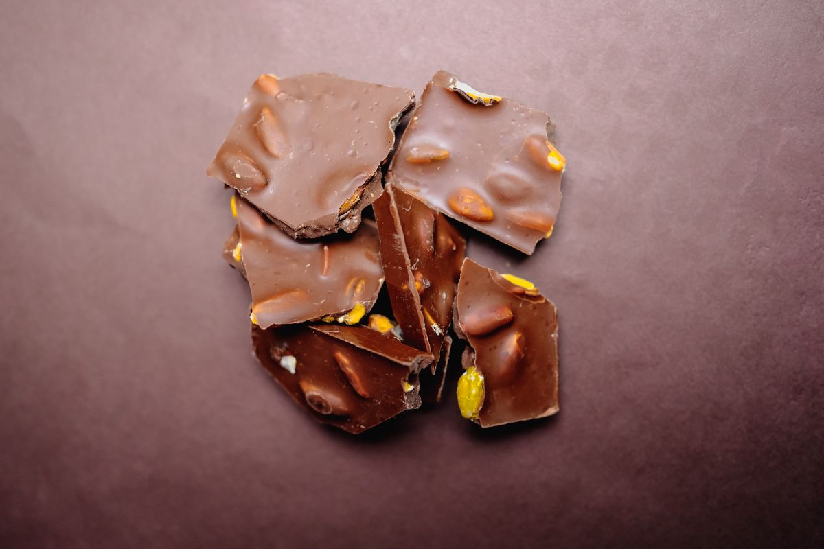 Top view of chocolate bark with almonds on a brown surface, perfect for dessert imagery.