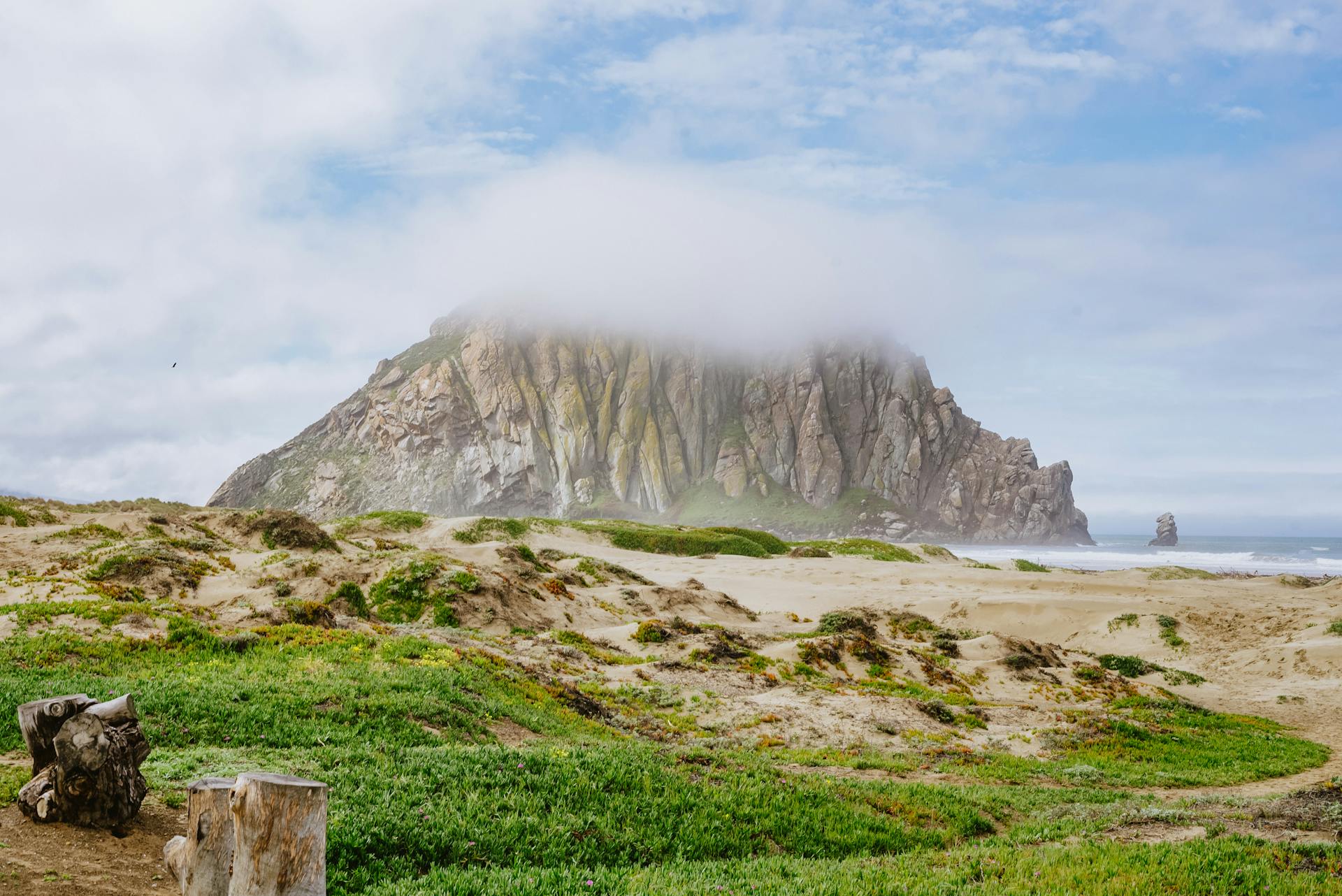 Breathtaking view of Morro Rock under clouds at Morro Bay Beach, California.