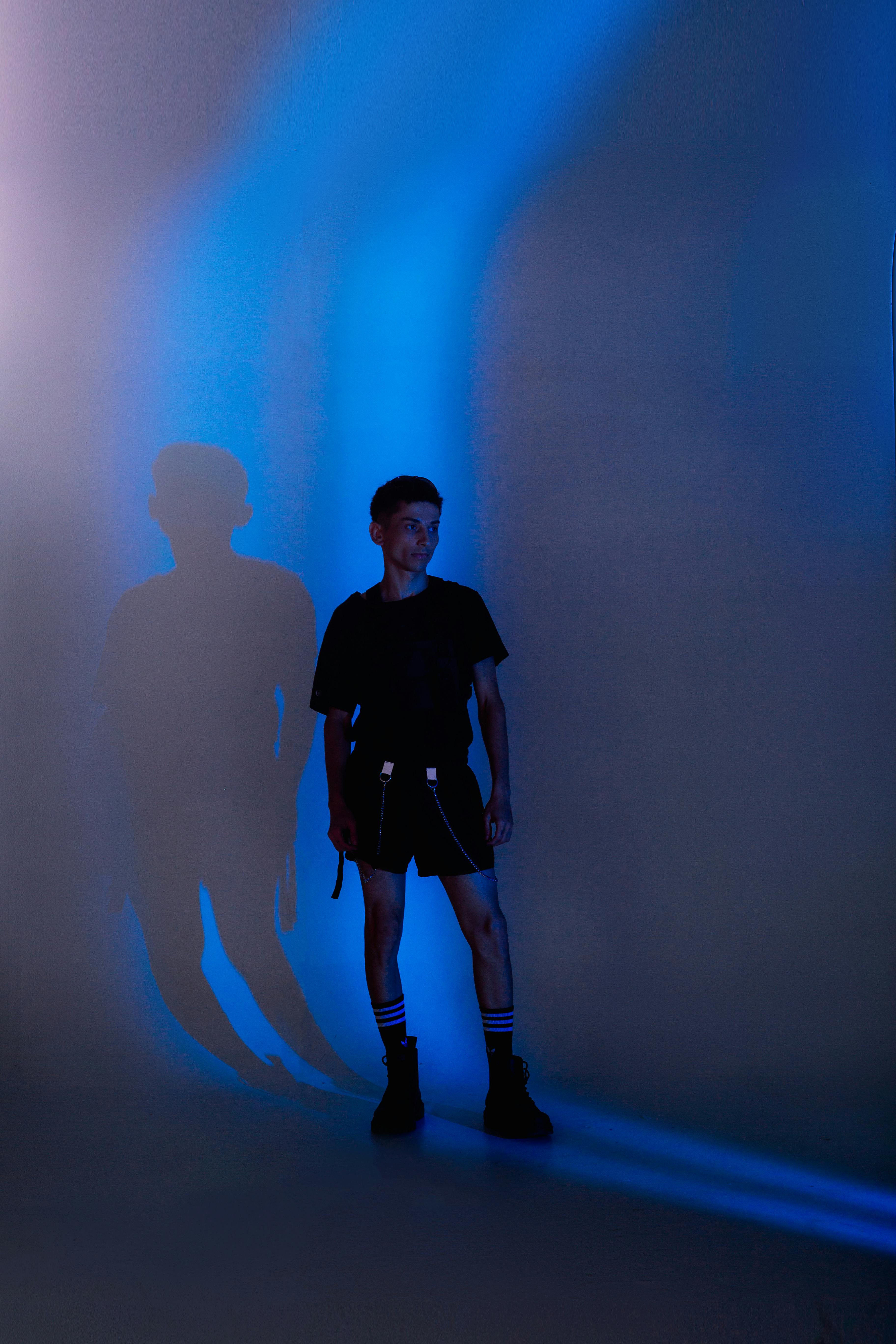 A man standing in front of a blue light photo – Free Light Image on Unsplash