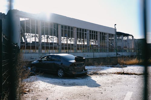 Abandoned Car by Ruins of Factory