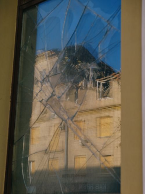 Free A shattered window pane reflecting a dilapidated building in Kharkiv, Ukraine. Stock Photo