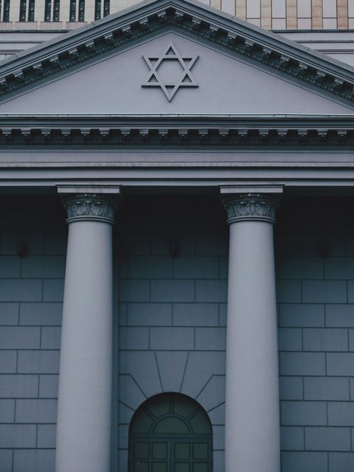 Free Close-up of a neoclassical building facade with columns and a Star of David symbol. Stock Photo