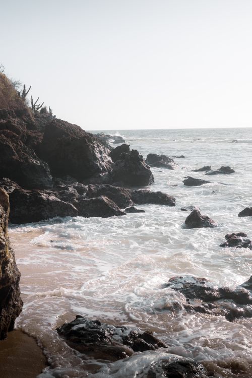 Free Waves crashing against rocky cliffs at Puerto Escondido, Mexico. Stock Photo