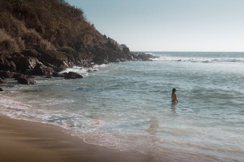 Woman Swimming in the Sea near a Shore 