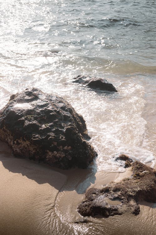 Free A beach with rocks and water in the background Stock Photo
