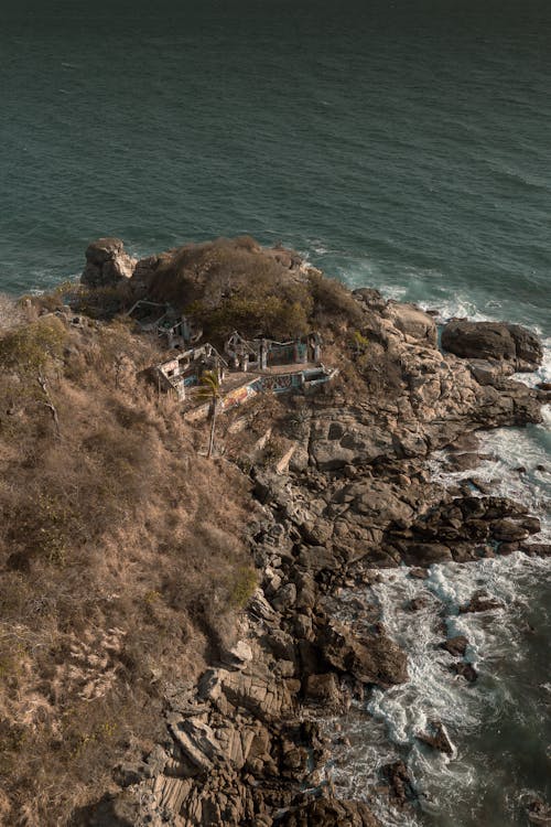 An aerial view of a small house on the beach