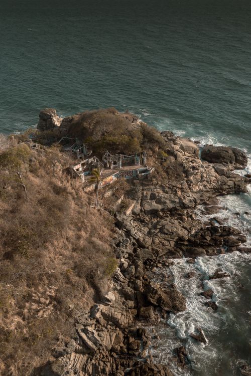 Free Aerial shot of a rugged coastline in Puerto Escondido, Mexico with ocean waves. Stock Photo