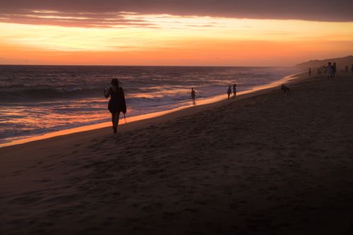 Free Silhouetted figures walk along a beach at sunset in Puerto Escondido, Mexico. Stock Photo