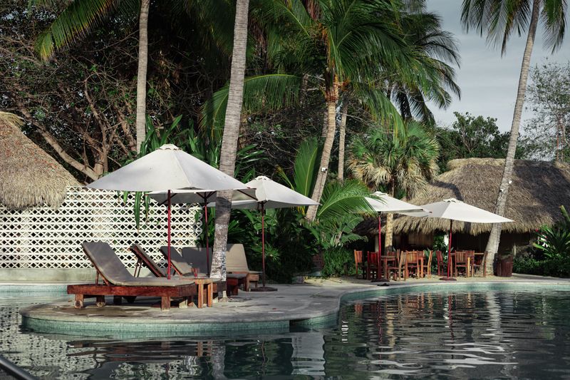 Community pool with loungers and parasols in golden light