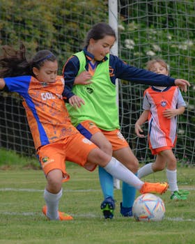 Three young girls actively playing a soccer match outdoors, showcasing team spirit and sportsmanship.