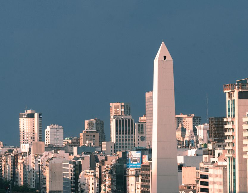 A stunning aerial view of Buenos Aires showcasing the iconic Obelisco surrounded by city skyscrapers.