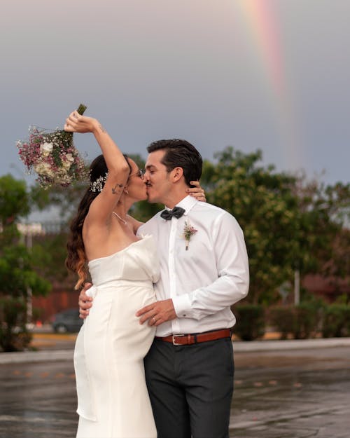 Newlyweds Kissing under Rainbow