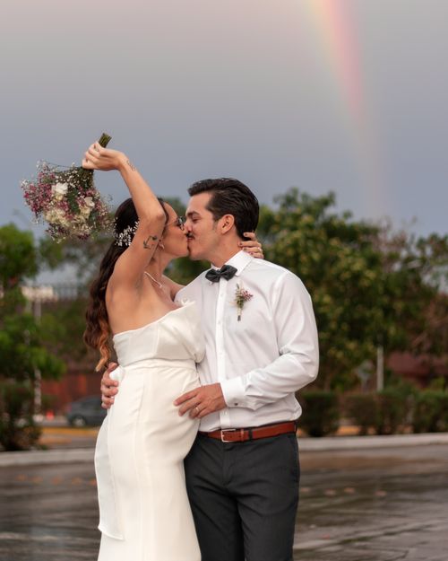 Free Newlyweds share a passionate kiss under a colorful rainbow in Mérida, Mexico. Stock Photo