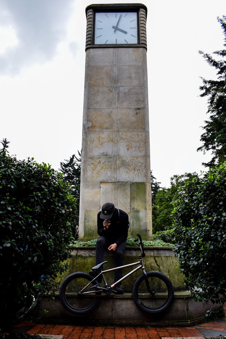 Man Sitting Under Clock