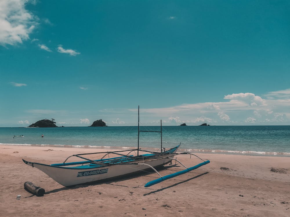 A Boat on the Beach and View of Island on the Horizon 