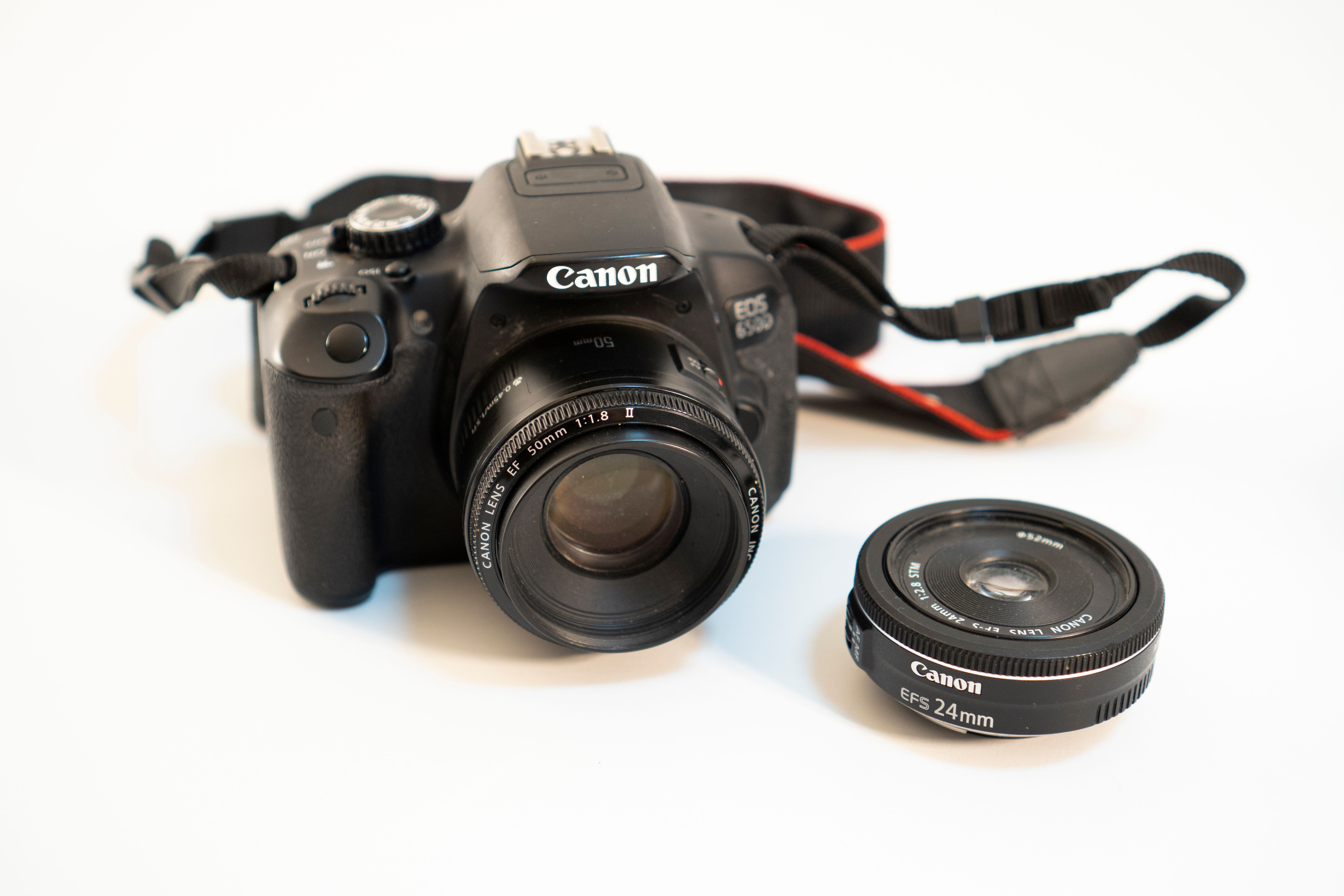 Detailed shot of a DSLR camera with detachable lens on a white background. Perfect for photography enthusiasts.