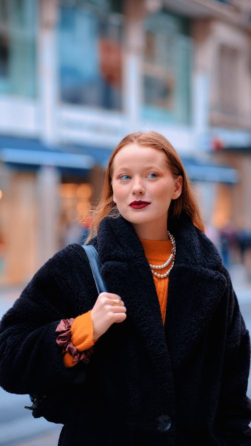 Elegant Woman in a Coat Standing on the Street in City 