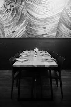 Stylish artistic interior of a restaurant with a set dining table in black and white.