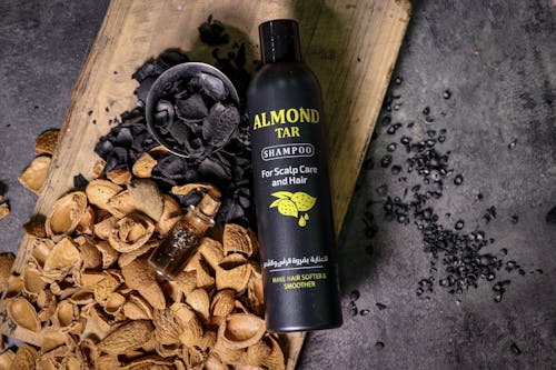 Shampoo in Black Bottle Among Walnut Shells